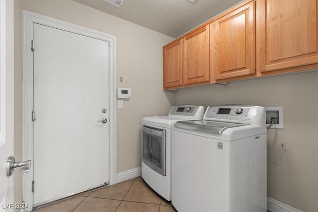 laundry area with cabinet space, baseboards, washer and dryer, and light tile patterned flooring