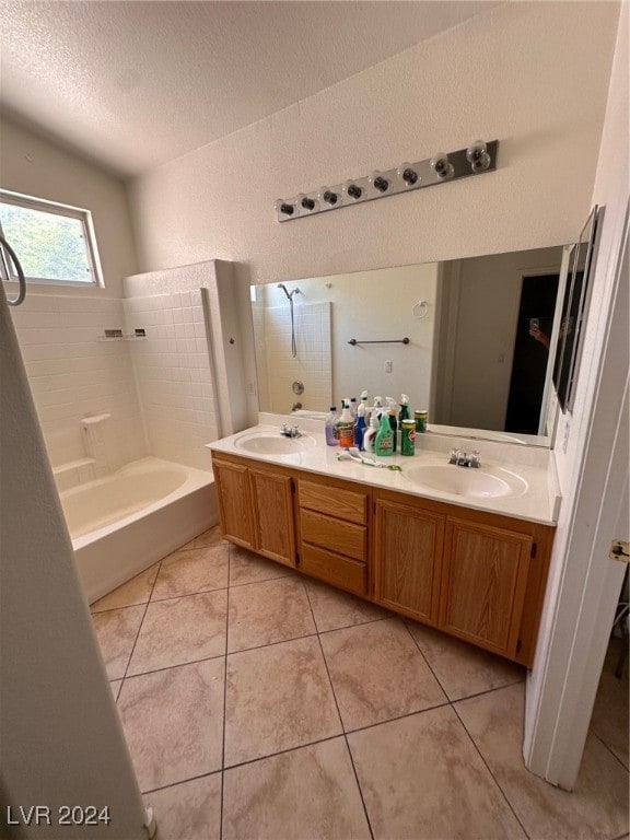 bathroom with shower / tub combination, tile patterned floors, vaulted ceiling, vanity, and a textured ceiling