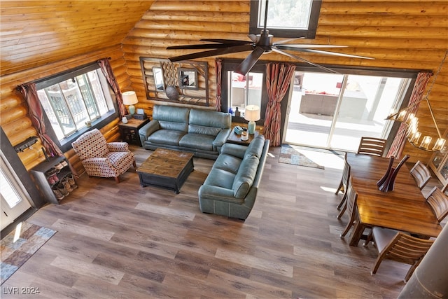 living room with rustic walls, dark hardwood / wood-style flooring, lofted ceiling with skylight, wooden ceiling, and ceiling fan