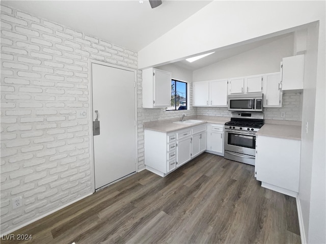 kitchen with lofted ceiling, dark hardwood / wood-style floors, appliances with stainless steel finishes, and white cabinets