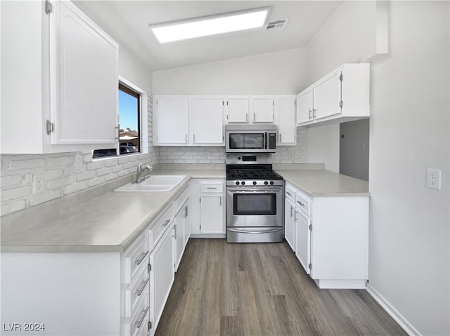 kitchen featuring backsplash, appliances with stainless steel finishes, sink, white cabinetry, and lofted ceiling