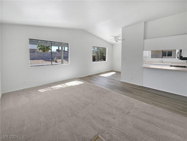 unfurnished living room with vaulted ceiling, wood-type flooring, and ceiling fan