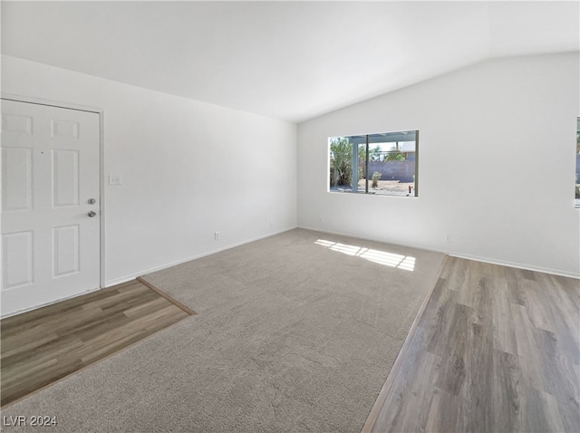 empty room featuring lofted ceiling and light hardwood / wood-style flooring