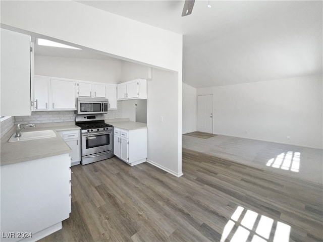 kitchen with vaulted ceiling, dark hardwood / wood-style flooring, appliances with stainless steel finishes, sink, and ceiling fan