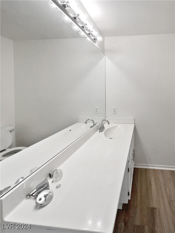 bathroom featuring vanity, toilet, and hardwood / wood-style flooring