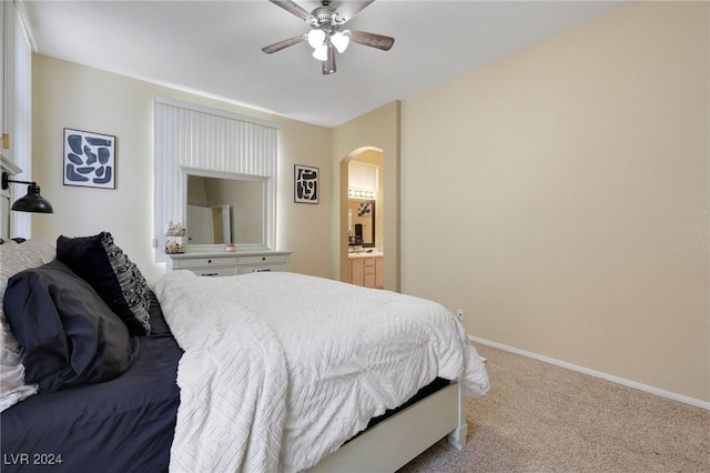 carpeted bedroom featuring arched walkways, baseboards, and a ceiling fan