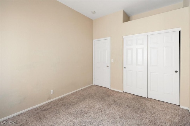 unfurnished bedroom with carpet floors, baseboards, and a closet