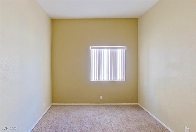 carpeted spare room featuring baseboards