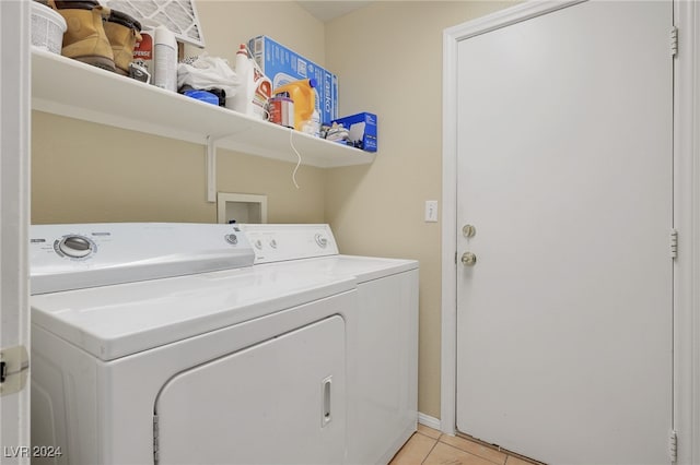 clothes washing area with washer and dryer and light tile patterned floors