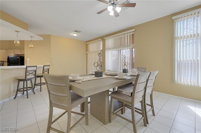 dining room with light tile patterned floors, baseboards, a ceiling fan, and visible vents