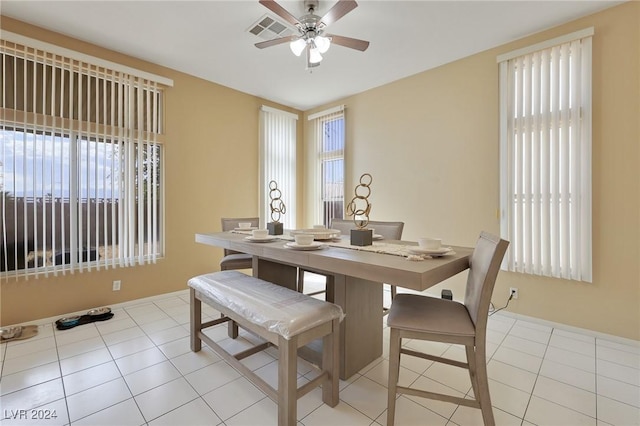 dining area featuring plenty of natural light, ceiling fan, light tile patterned floors, and visible vents