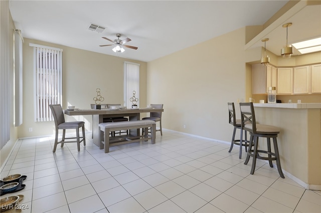 tiled dining space with plenty of natural light and ceiling fan