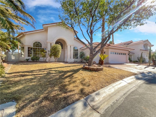 mediterranean / spanish-style house with a front yard and a garage