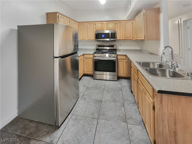 kitchen featuring light brown cabinets, stainless steel appliances, light tile patterned flooring, and sink