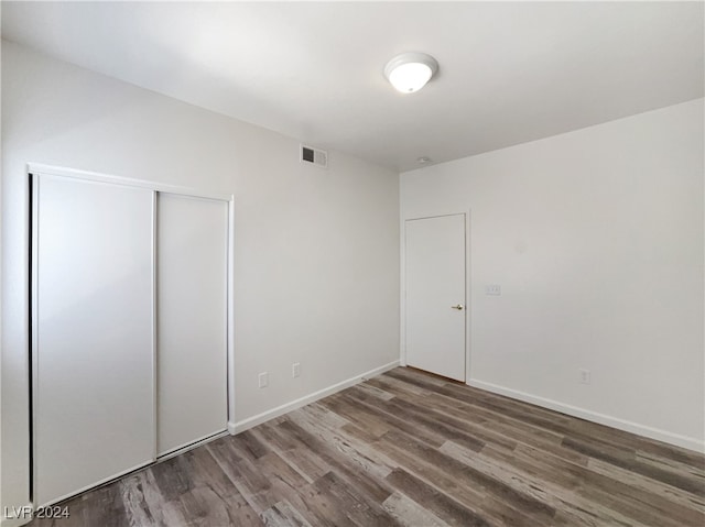 unfurnished bedroom with a closet and hardwood / wood-style floors