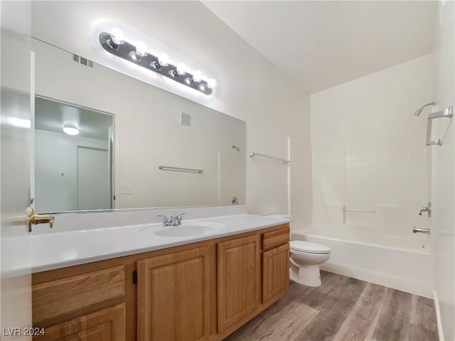 full bathroom featuring vanity, hardwood / wood-style floors, toilet, lofted ceiling, and tub / shower combination