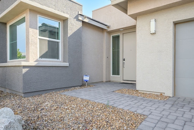 view of exterior entry featuring a patio area