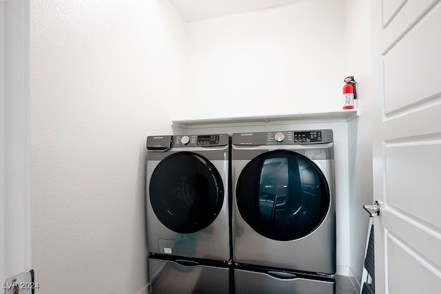 clothes washing area with washer and clothes dryer