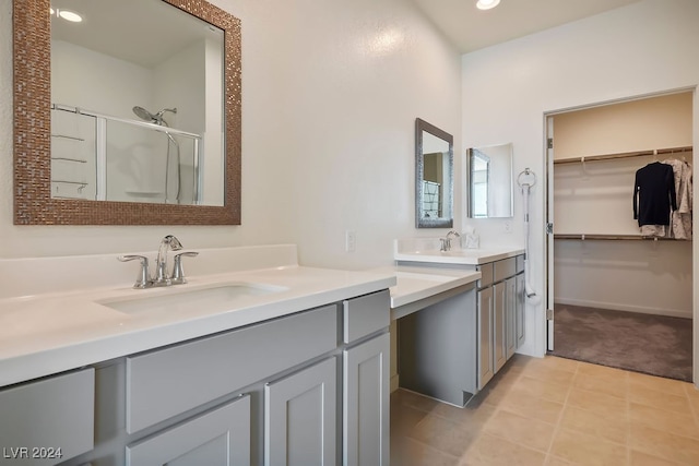 bathroom with tile patterned flooring, vanity, and walk in shower