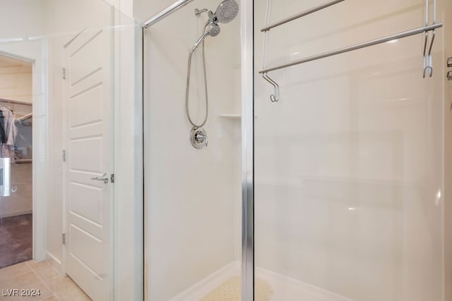 bathroom with an enclosed shower and tile patterned floors