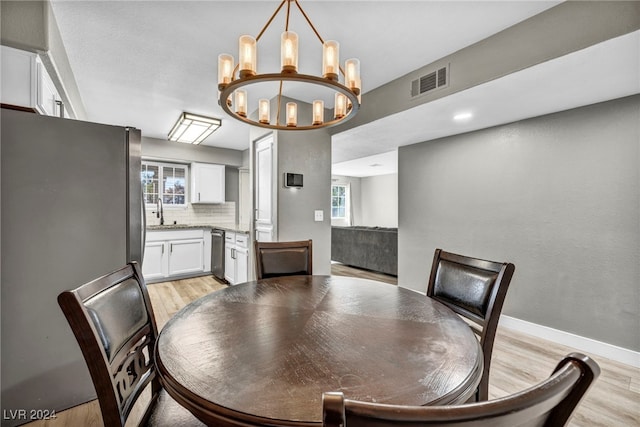 dining area featuring an inviting chandelier and light hardwood / wood-style floors