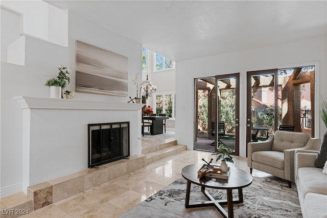 living room with a tiled fireplace and an inviting chandelier