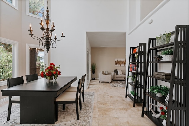 dining space with an inviting chandelier and a high ceiling