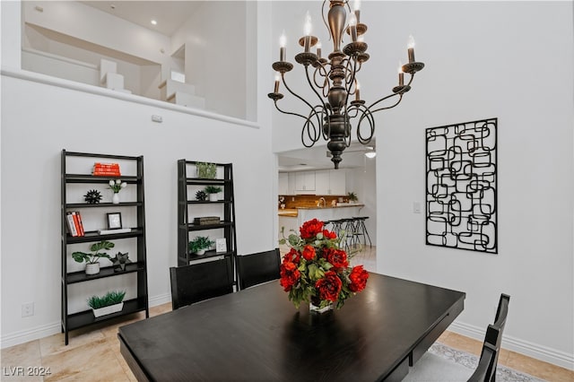 dining area featuring an inviting chandelier and a towering ceiling