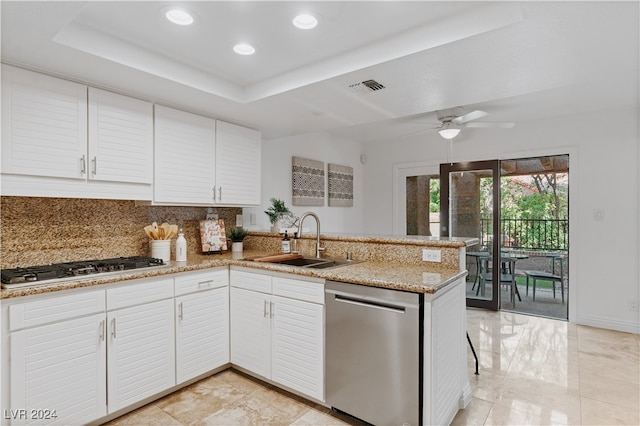 kitchen with sink, white cabinetry, appliances with stainless steel finishes, kitchen peninsula, and a raised ceiling