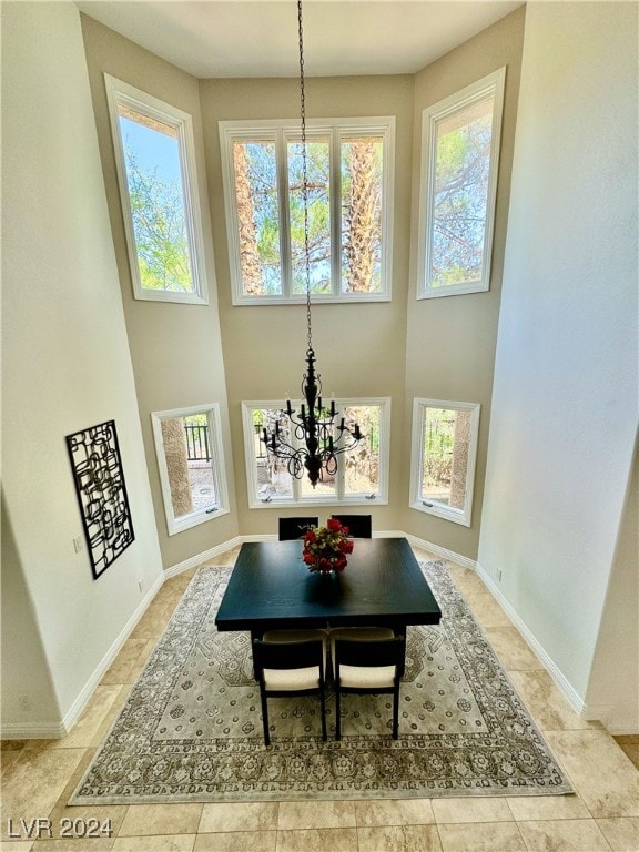 dining space with an inviting chandelier and a towering ceiling