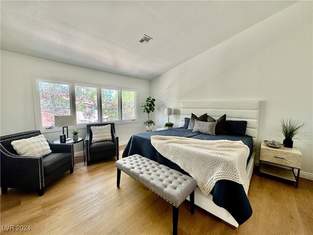 bedroom featuring hardwood / wood-style flooring and a textured ceiling