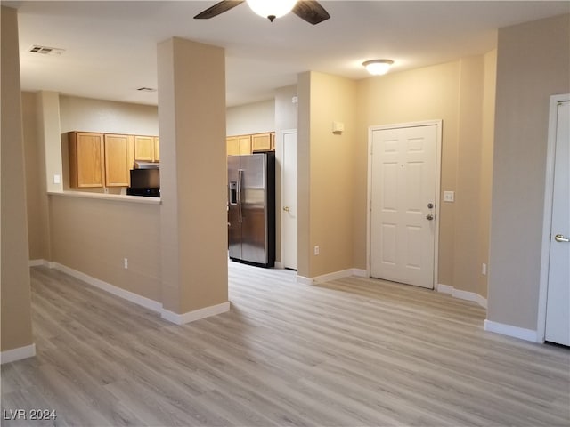 unfurnished living room featuring ceiling fan and light hardwood / wood-style flooring