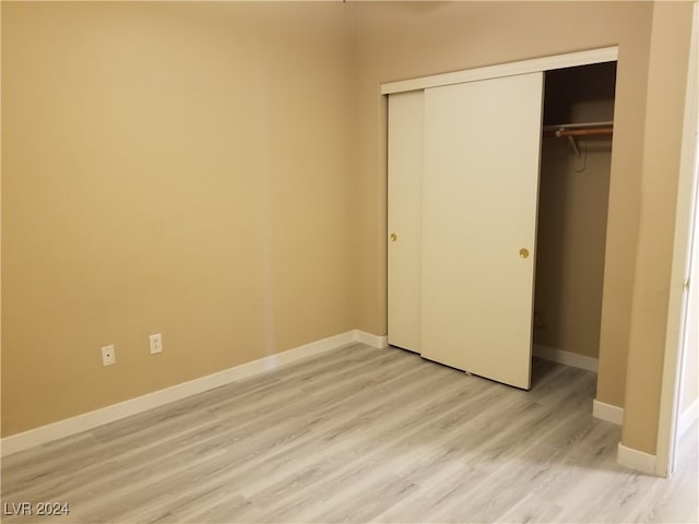 unfurnished bedroom with a closet and light hardwood / wood-style flooring