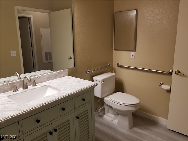 bathroom with wood-type flooring, toilet, and vanity