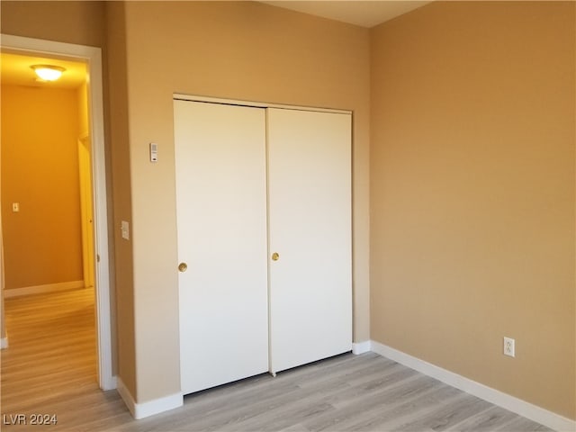 unfurnished bedroom featuring light wood-type flooring and a closet