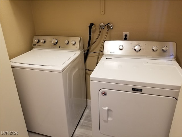 washroom featuring light hardwood / wood-style flooring and separate washer and dryer