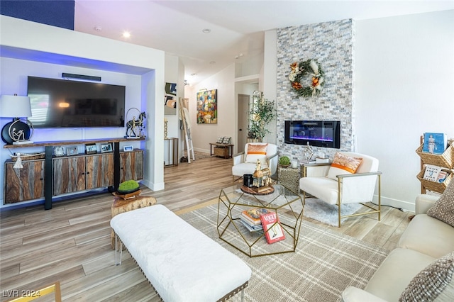 living room with vaulted ceiling, wood-type flooring, and a fireplace