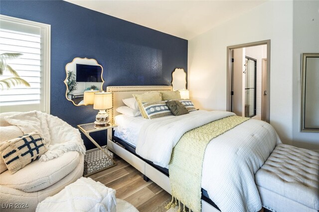 bedroom with lofted ceiling and hardwood / wood-style flooring