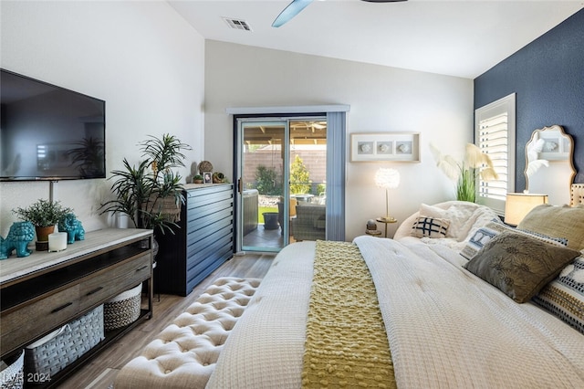 bedroom featuring hardwood / wood-style floors, ceiling fan, access to exterior, and vaulted ceiling