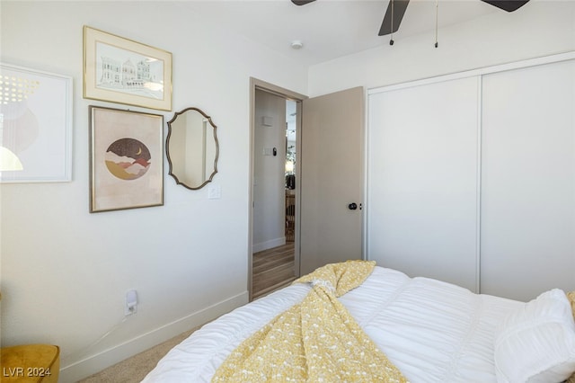 carpeted bedroom with ceiling fan and a closet