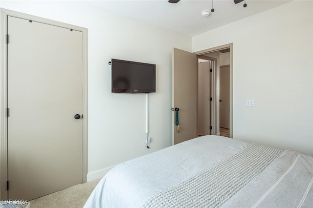 carpeted bedroom featuring ceiling fan and a closet