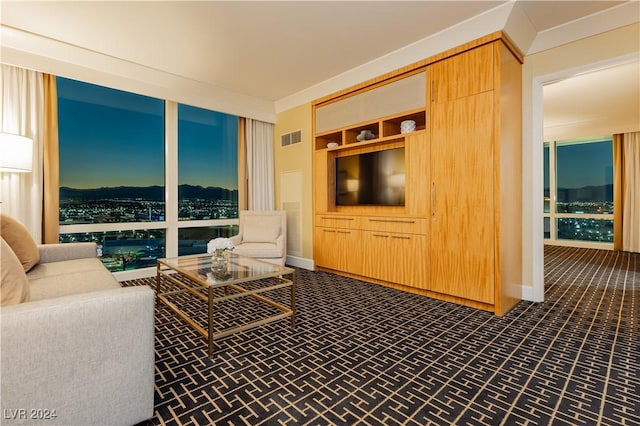 living area with ornamental molding, visible vents, and baseboards