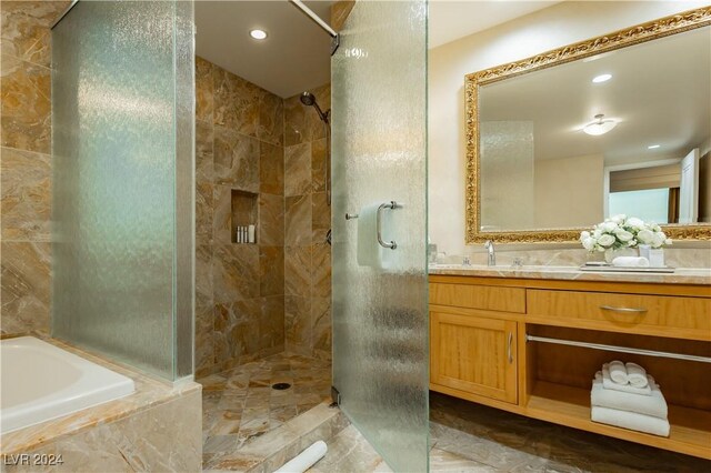 bathroom with shower with separate bathtub and vanity