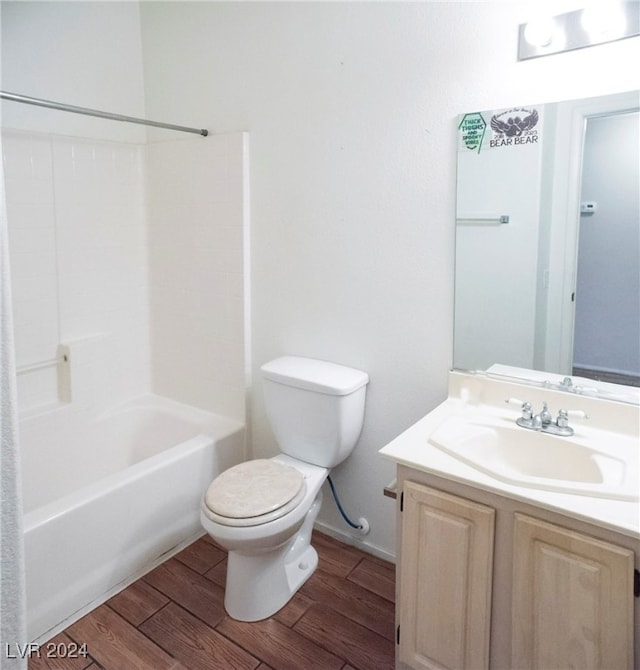 full bathroom featuring hardwood / wood-style floors, toilet,  shower combination, and vanity