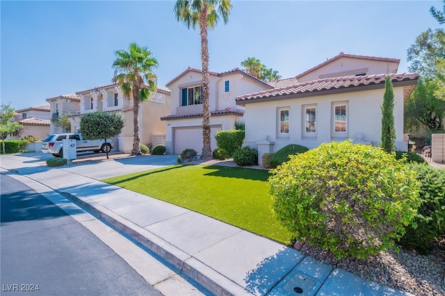 mediterranean / spanish-style house with a garage and a front lawn