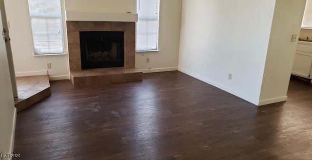 unfurnished living room featuring a fireplace, plenty of natural light, and dark hardwood / wood-style floors