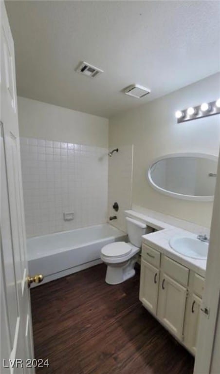 full bathroom featuring vanity, toilet, hardwood / wood-style flooring, and tiled shower / bath