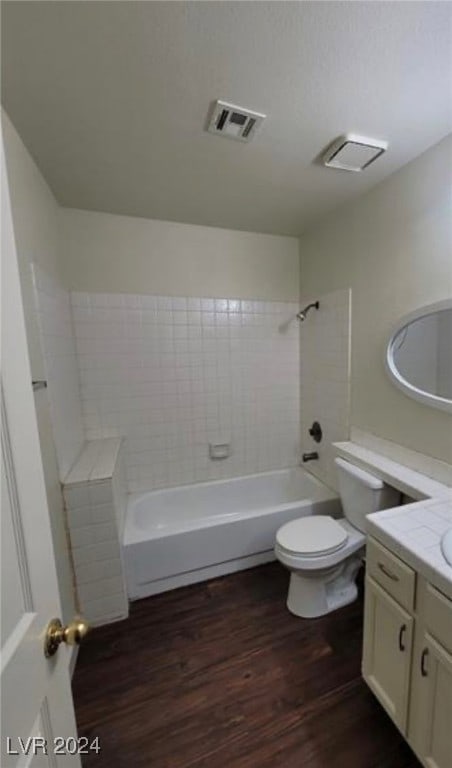 full bathroom featuring tiled shower / bath combo, vanity, toilet, and hardwood / wood-style flooring