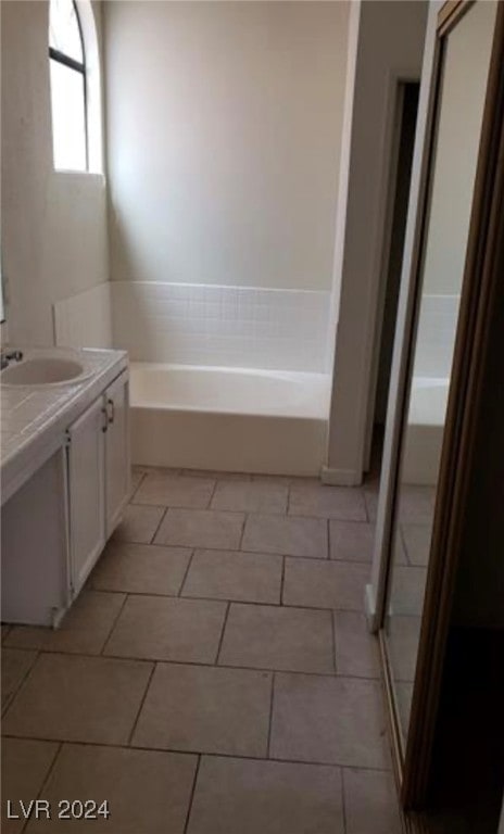 bathroom with vanity, tile patterned floors, and a washtub