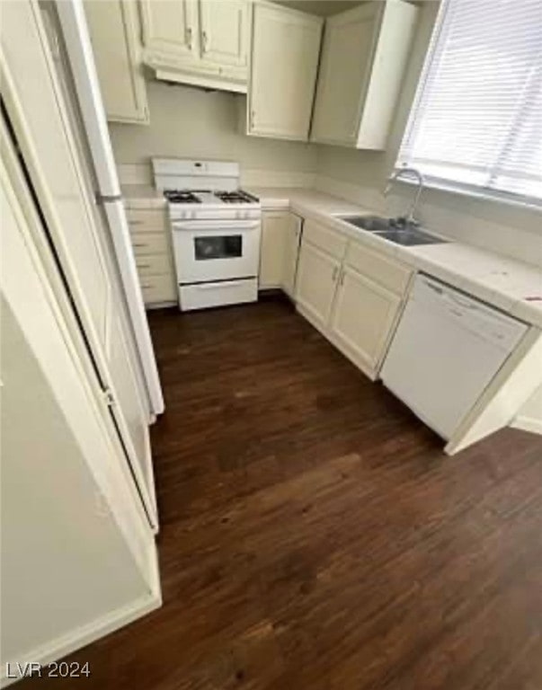 kitchen with sink, dark hardwood / wood-style floors, white appliances, and white cabinetry